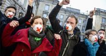 protest tegen GAS-wet, met mensen met mondmaskers met daarop een rood kruis